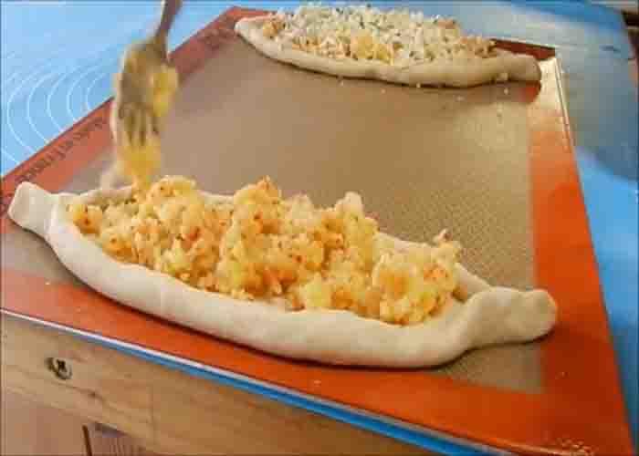Dividing the potato filling on each potato pide