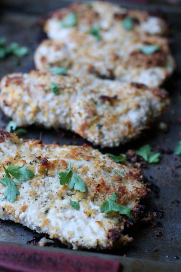 Healthy baked cheddar ranch chicken, golden panko crusted chicken cutlets on a dark baking sheet with parsley