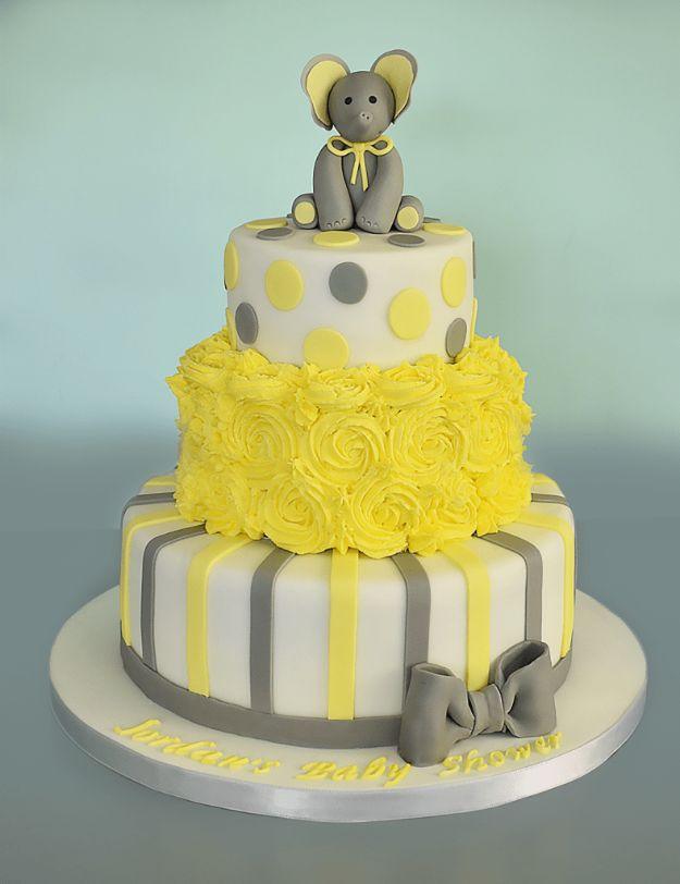 Three tier baby shower cake in yellow and grey with stripes, rosettes, dots and a fondant elephant on top