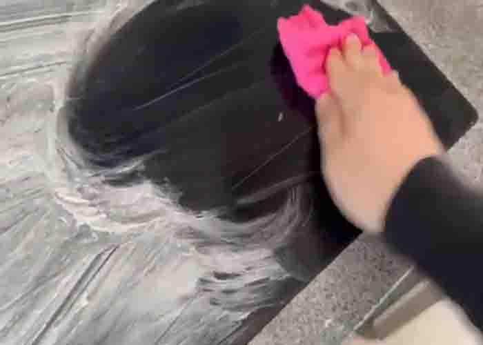 Wiping the glass-top stove to remove the shaving cream