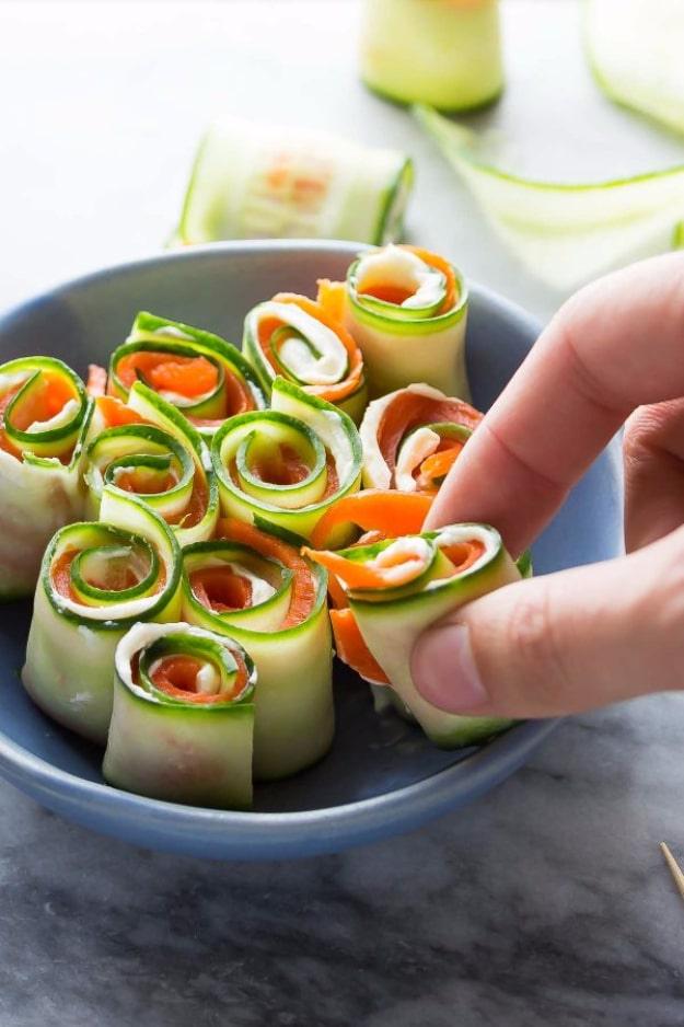 Smoked salmon cucumber roll ups, thin cucumber ribbons wrapped around salmon and secured on a serving platter