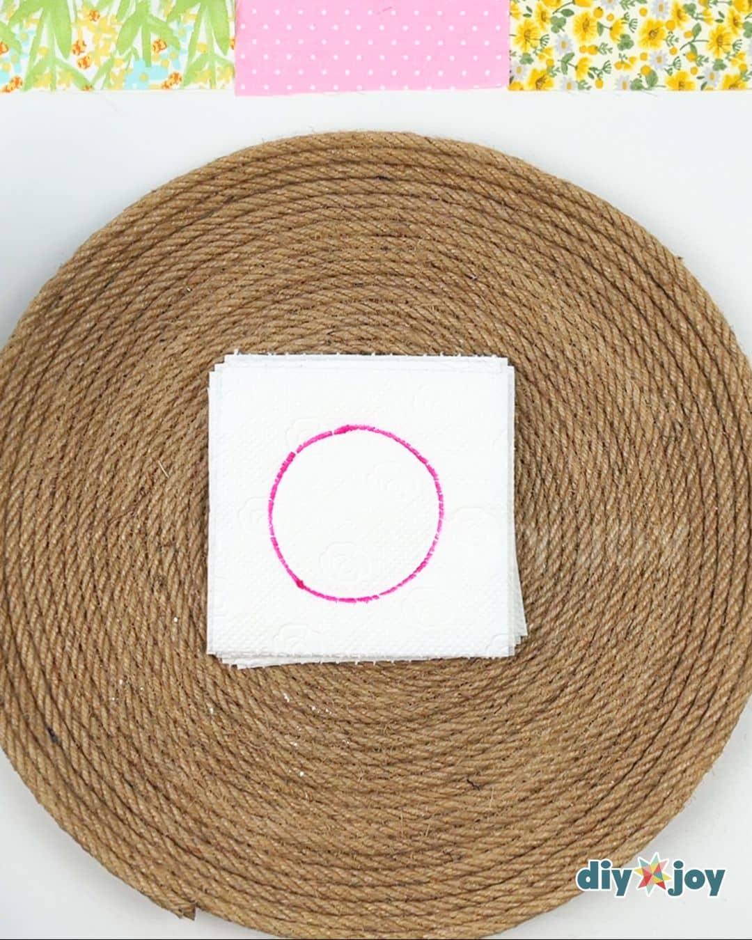 Stacking and tracing step for toilet paper flowers, layers of tissue traced around a paper cup rim in pencil