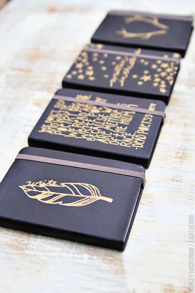 Simple sharpie journals in navy with metallic gold antlers, stars, a feather and lettering drawn on the covers