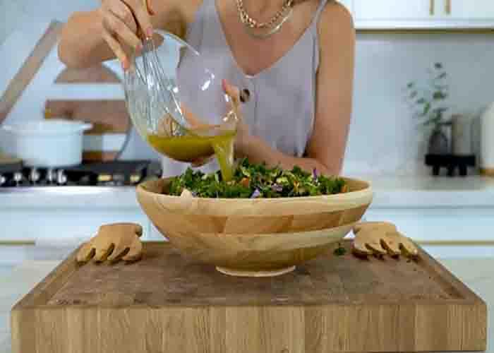 Drizzling the dressing over the winter salad