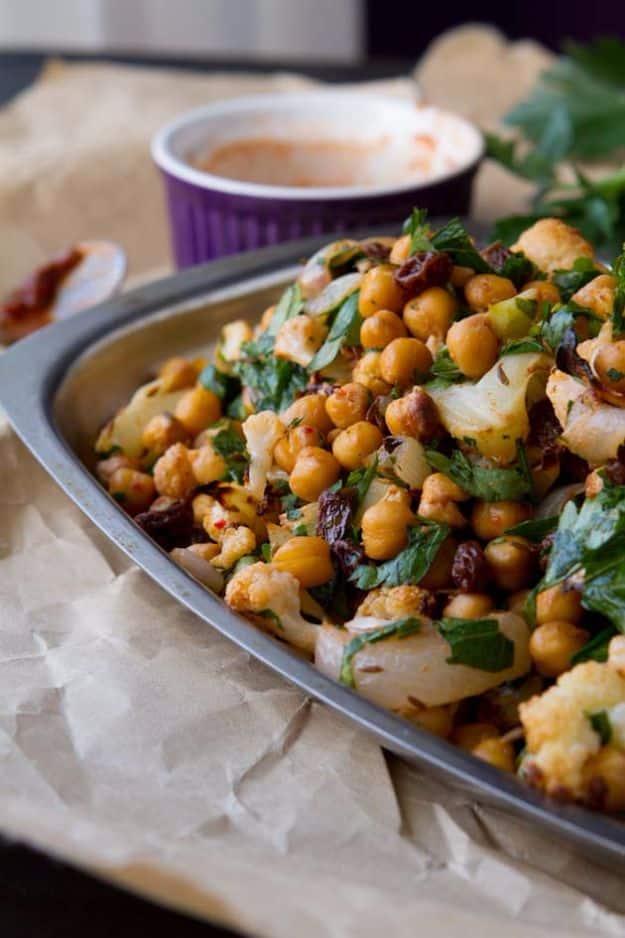 Roasted cauliflower salad with chickpeas, raisins, fresh parsley and cilantro in a spicy harissa dressing