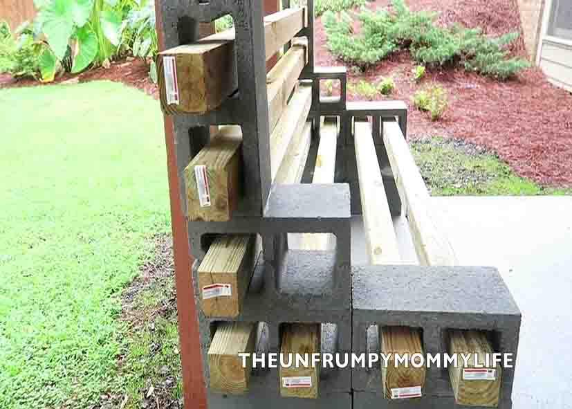 Placing the 4x4 posts to through the holes of the cinder blocks