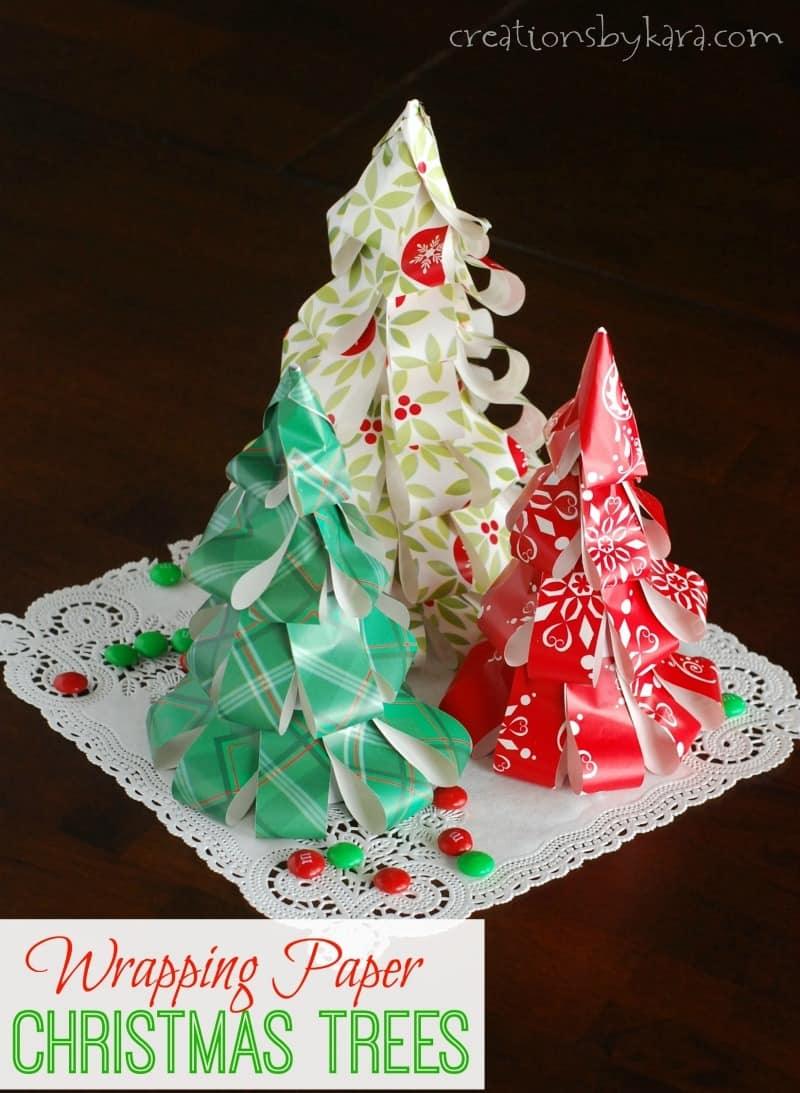 Three cone trees covered in looped strips of red, green and holly print wrapping paper on a white paper doily