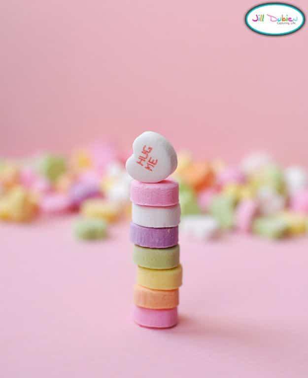 Valentine's Day candy heart game with children picking up pastel conversation hearts using chopsticks