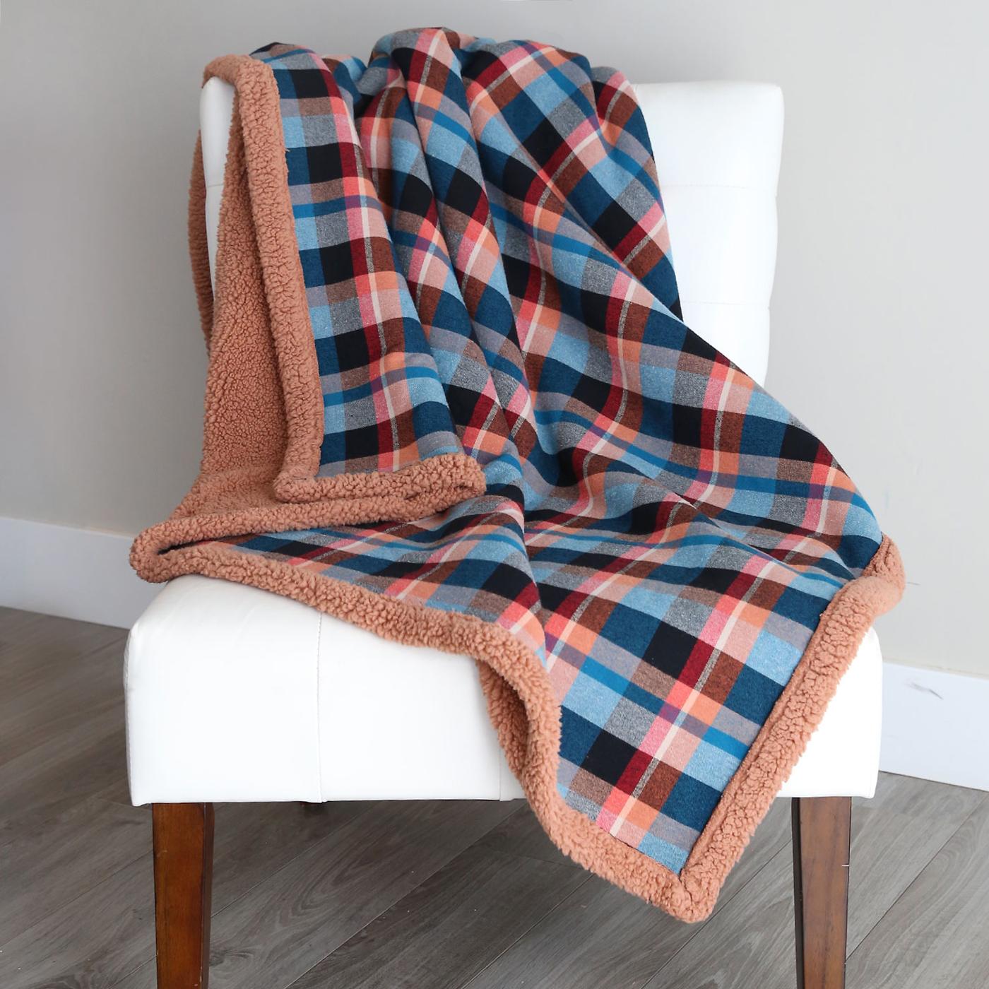 Flannel and sherpa blanket, an easy home sewing project with a blue plaid throw and tan sherpa backing over a chair