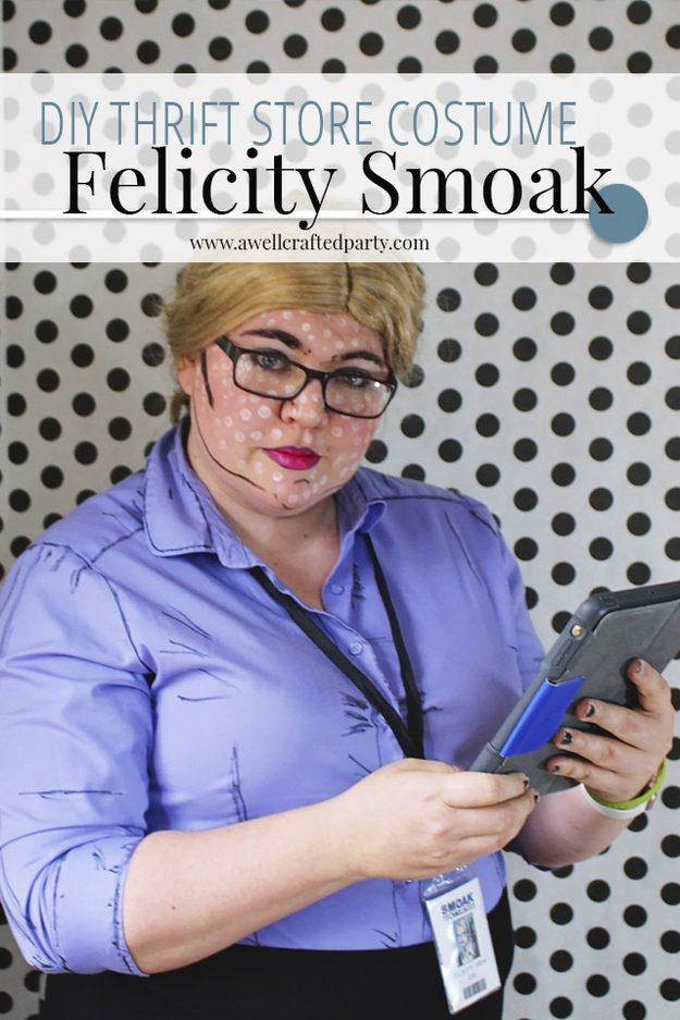 Woman dressed as Felicity Smoak in a blue shirt with drawn seam lines, blonde wig, glasses, badge and tablet
