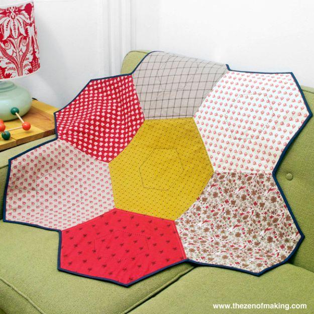 Giant hexie flower lap quilt, six large printed hexagons around a yellow center on a green midcentury sofa