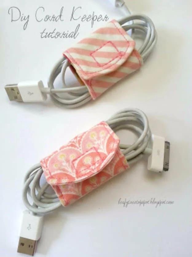 Two fabric scrap cord keepers with snap flaps in pink stripe and coral print wrapped around coiled white charging cables
