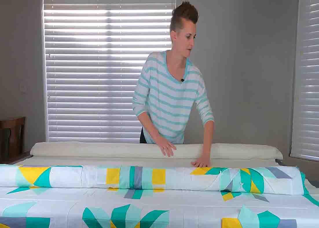 Unrolling the quilt parts then spray basting them