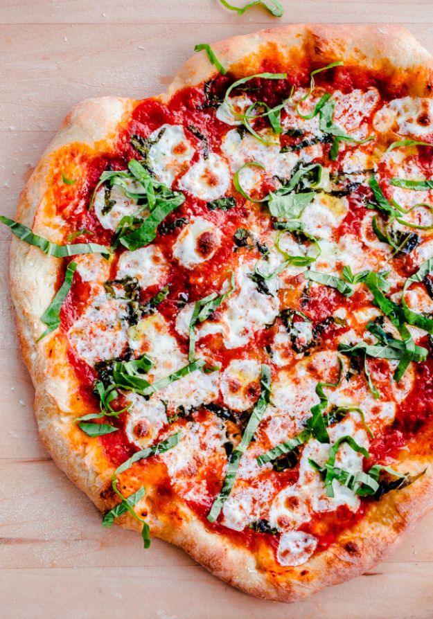 Homemade margherita pizza with a blistered crust, rounds of fresh mozzarella, red sauce and torn basil