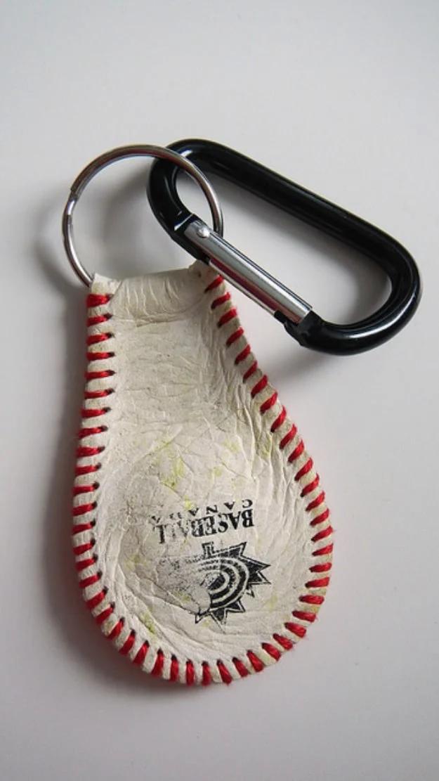 Keychain made from a flattened baseball leather panel with red stitching, on a split ring with a black carabiner