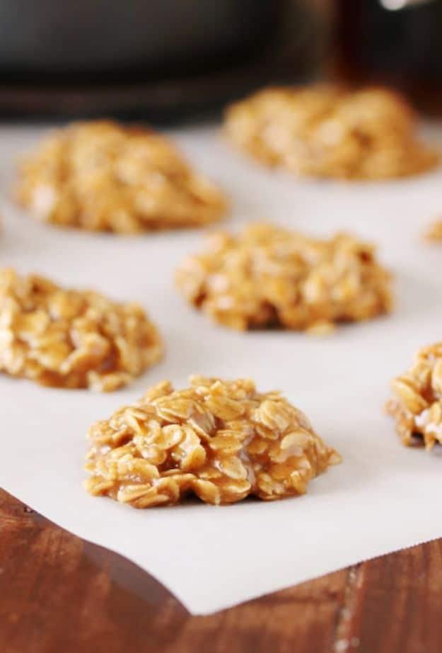 Vermont maple no bake cookies, pale golden oat mounds sitting on white parchment over a dark wood table