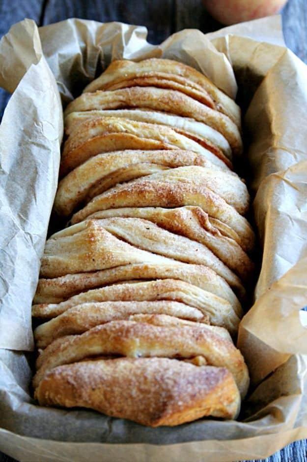 Apple pie pull apart bread with canned biscuits stacked upright in a loaf pan and finished with glaze
