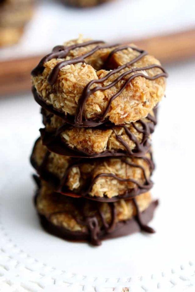 Healthy no bake samoa cookies, toasted coconut rounds with a dark chocolate drizzle stacked on white