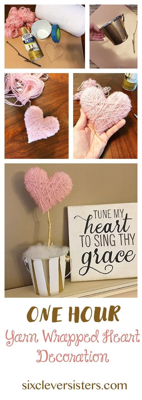 A cardboard heart form wound tightly with coral yarn and hung from a ribbon loop on a pale painted door