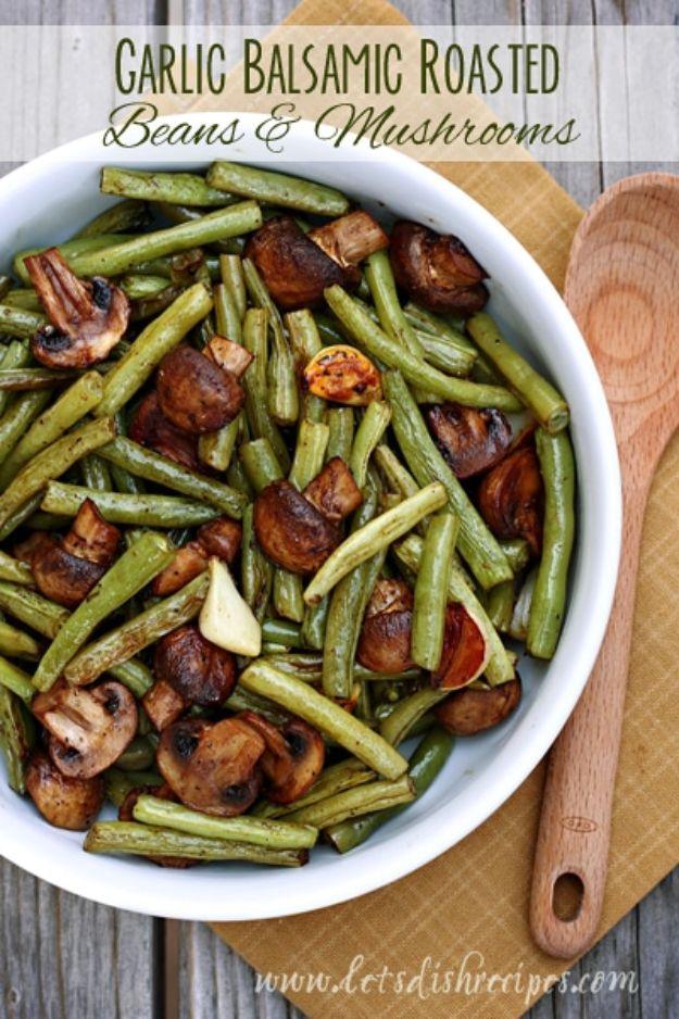 Balsamic garlic roasted green beans and mushrooms on a sheet pan with whole garlic cloves and browned edges