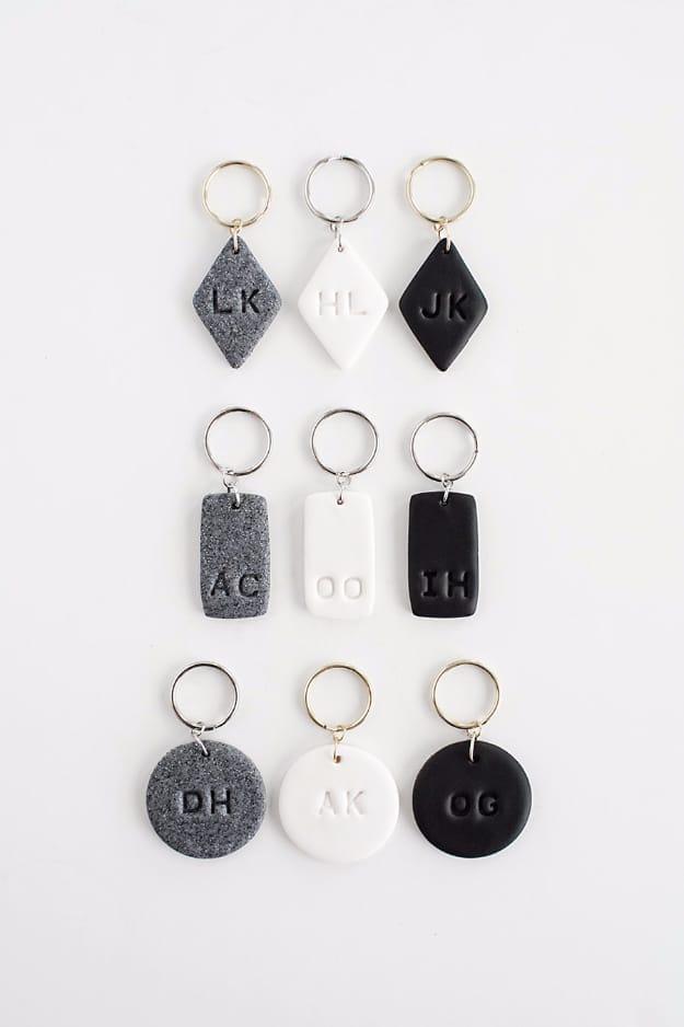 Nine black, white and granite polymer clay keychains stamped with initials on diamond, rectangle and circle shapes