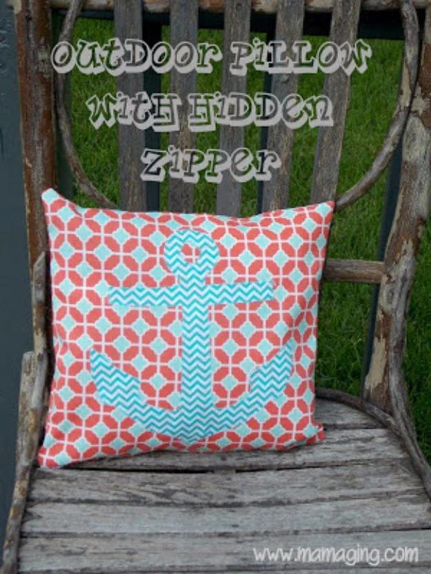 Outdoor pillow in coral and aqua print with an appliqued anchor, on a rustic twig chair, under a title graphic