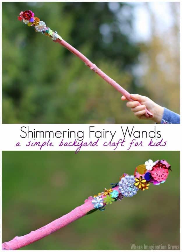 Pink painted stick fairy wand covered in sequins and flower shapes at one end, held up against trees and grass