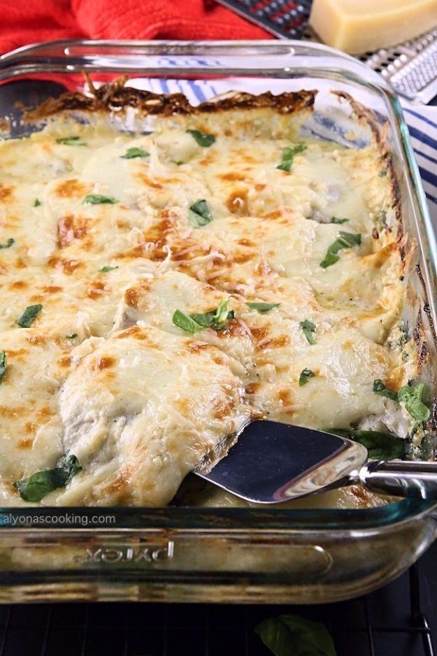 Creamy baked tilapia and spinach casserole browned in a glass baking dish with a serving spatula in it