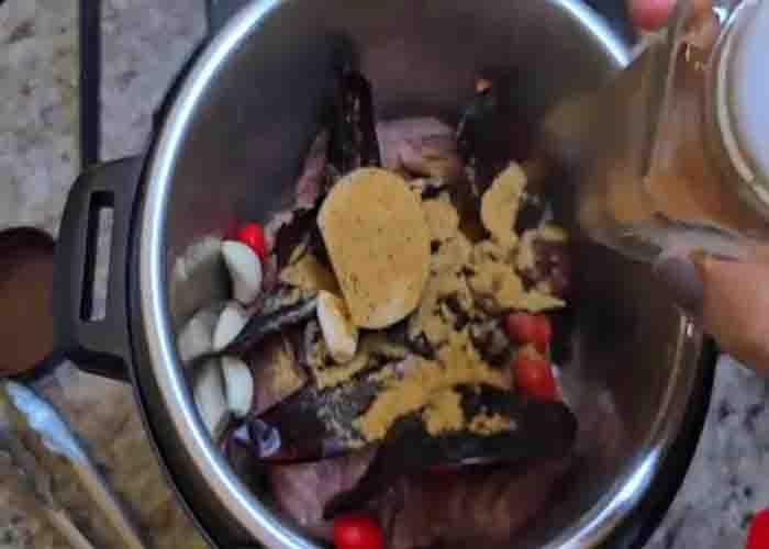 Adding the birria ingredients in the crockpot