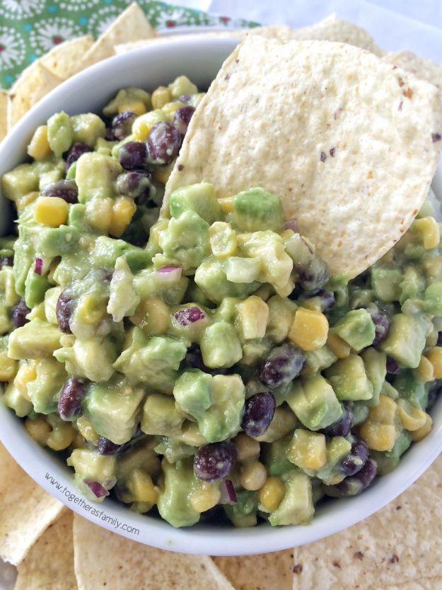 Avocado dip in a bowl with chunky avocado, sweet corn, black beans and red onion in tangy salsa verde
