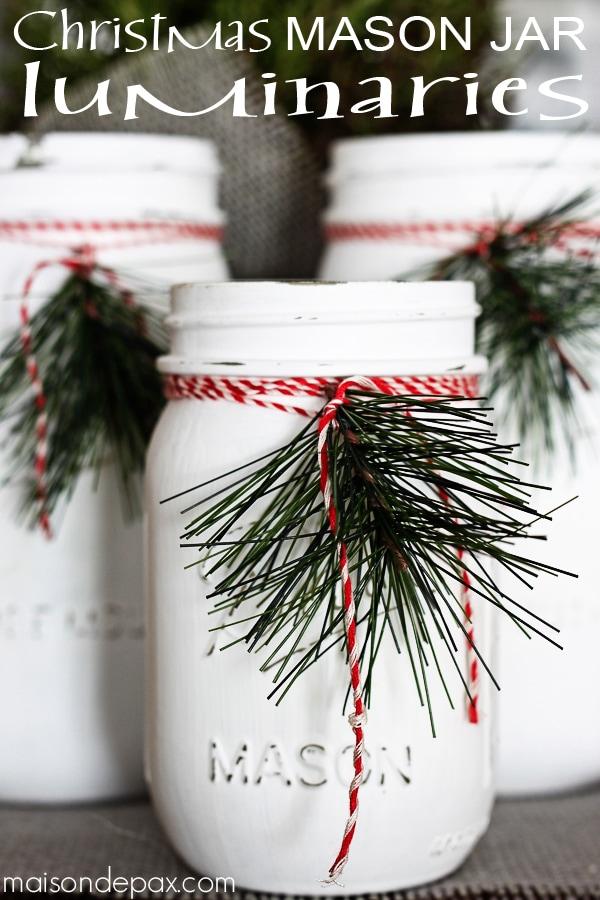 White painted mason jars tied with red and white twine and pine sprigs, with the title Christmas Mason Jar Luminaries