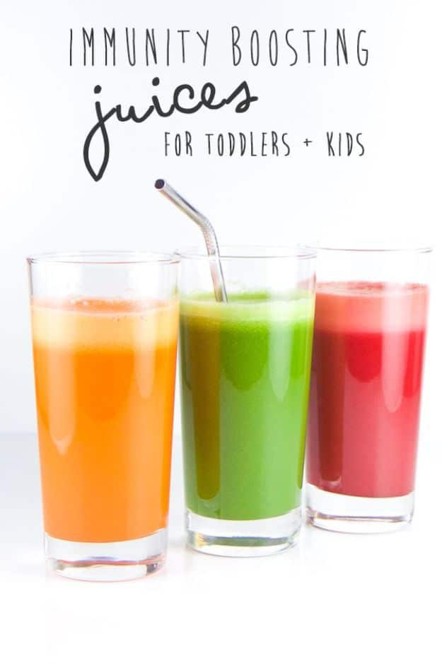Immunity boosting juices for kids lined up in three glasses, one orange, one green and one bright red