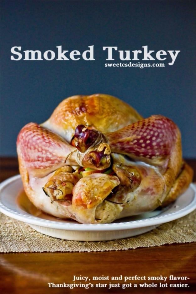 Perfect smoked turkey with dark burnished skin, resting whole on a board after coming off the smoker