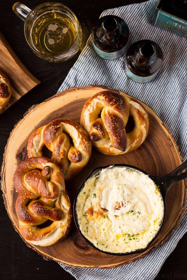 Beer cheese dip in a bowl beside soft golden baked beer pretzels with coarse salt, ready for dunking