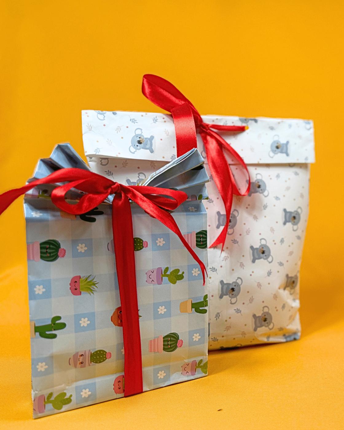 Last Minute Gift Ideas - two finished paper gift bags in cactus print and koala print with red ribbons