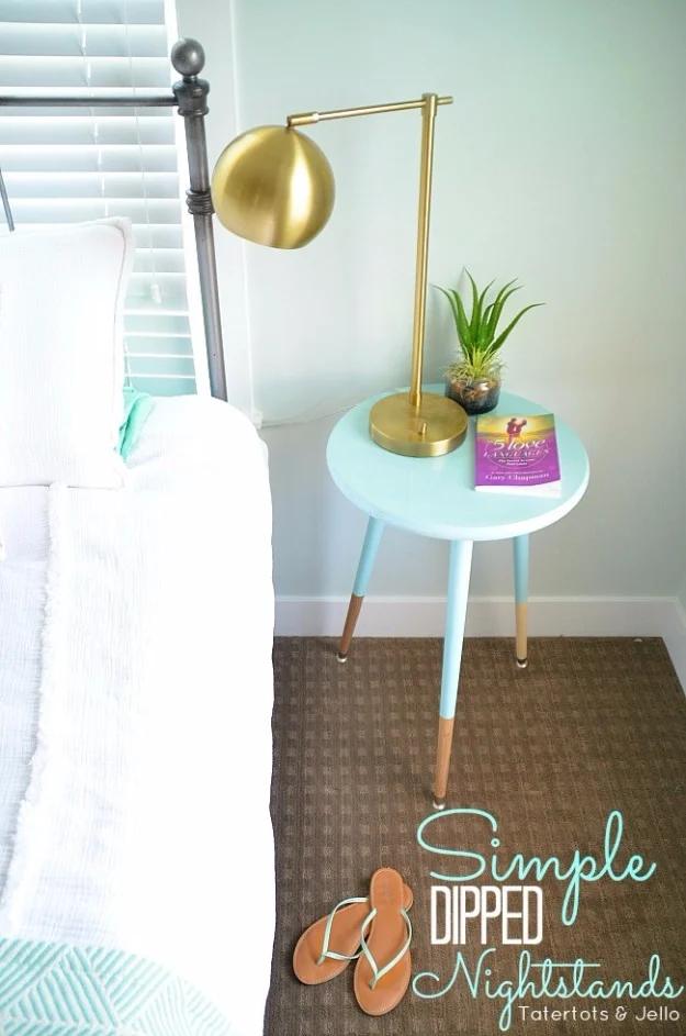 DIY dipped nightstand, a small round pale aqua side table with tapered legs dipped in matching paint beside a white bed