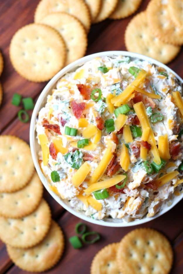 Million dollar dip in a bowl with cheddar, crumbled bacon, green onions and almonds through cream cheese
