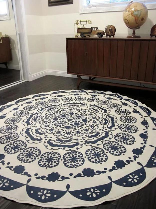 Round navy and cream medallion DIY rug made from a tablecloth on dark floorboards beside a walnut credenza