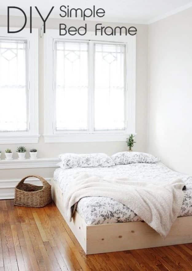 DIY simple bed frame graphic showing a low pine board frame around a white made bed on a bare wood floor