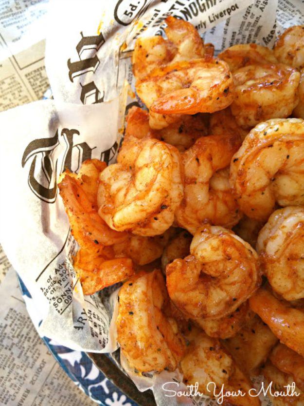 Party shrimp in paprika seasoning, piled into a bowl lined with newspaper print and ready to serve to a crowd