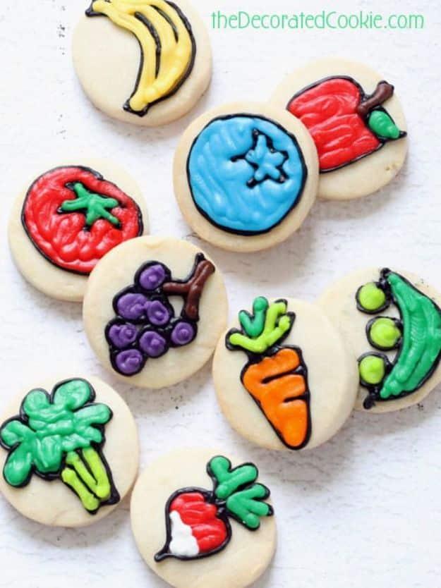 Bite sized fruit and veggie cookies, small round cookies iced as strawberries, carrots and citrus slices