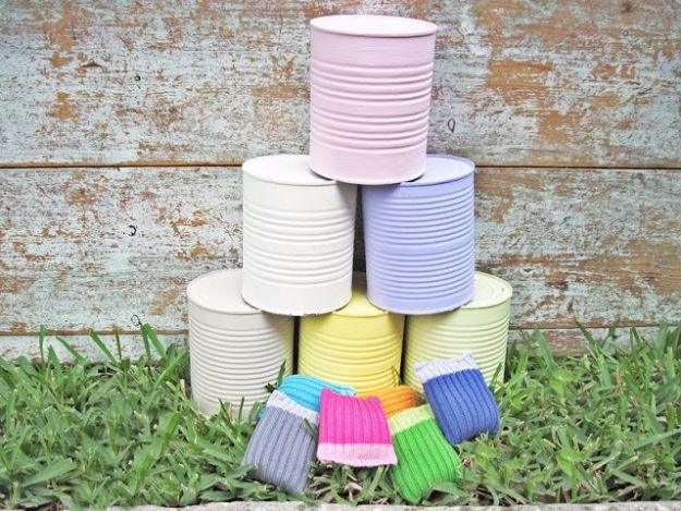 Crazy cans backyard game with pastel painted tin cans stacked in a pyramid and small striped bean bags on the grass