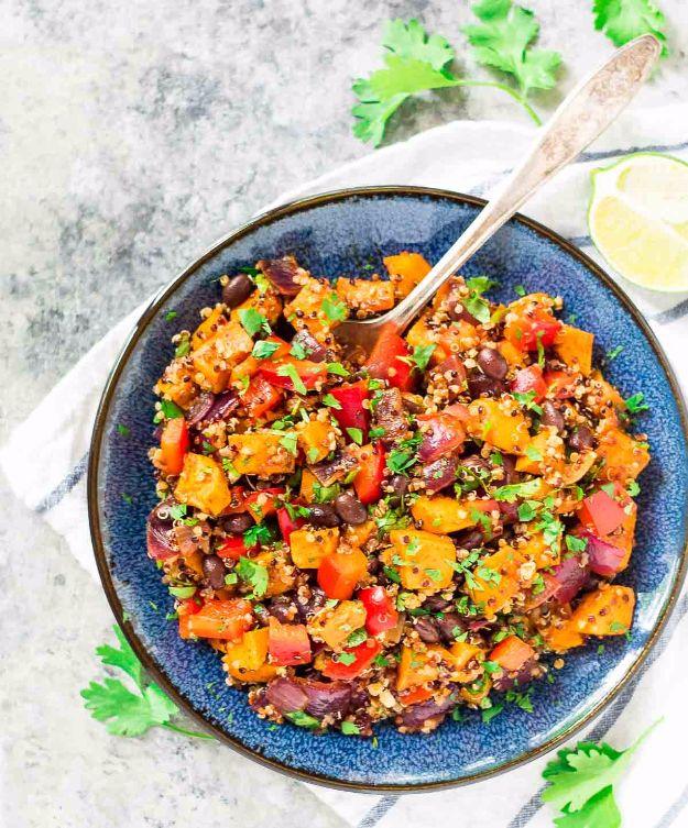 Roasted sweet potato quinoa black bean salad with orange sweet potato cubes, red pepper and cilantro in a blue bowl