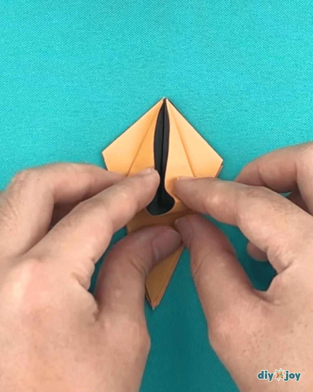 DIY easy paper flowers, a lily folded from one square with the bottom point turned up to finish the base