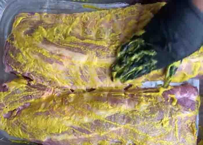 Coating the baby back ribs with mustard