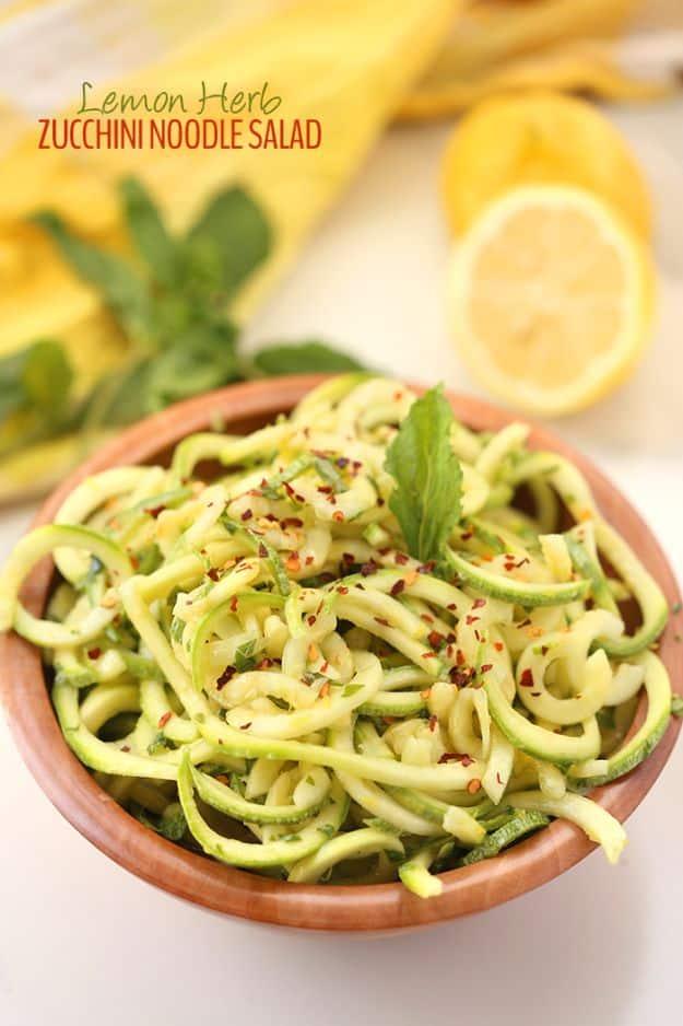 Lemon herb zucchini noodle salad, spiralized zucchini with red chili flakes and a mint sprig in a terracotta bowl