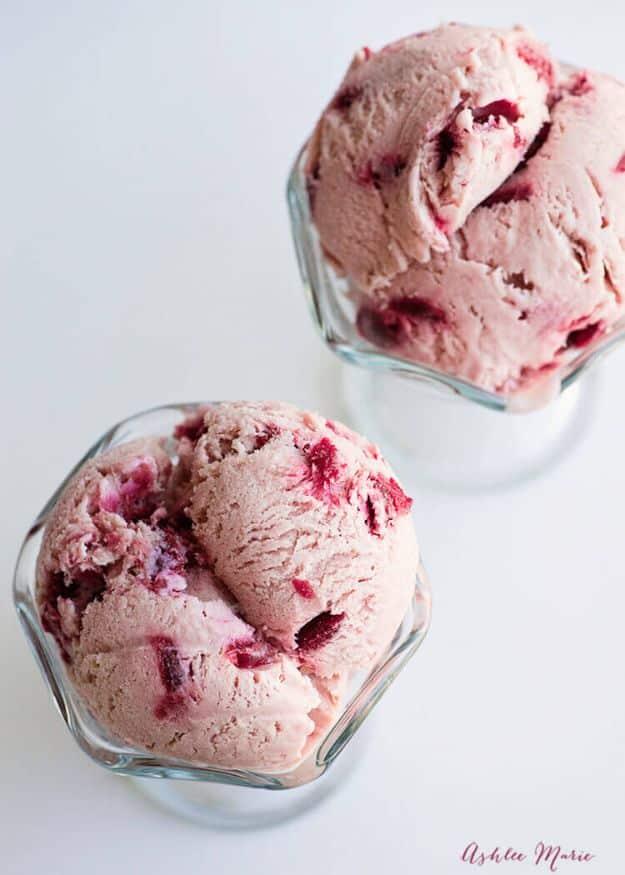 Almond cherry ice cream with pieces of cooked cherry running through pale pink scoops, a custard dessert