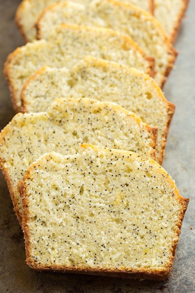 Lemon poppy seed bread cut into thick slices and lined up along a wooden board showing the speckled crumb
