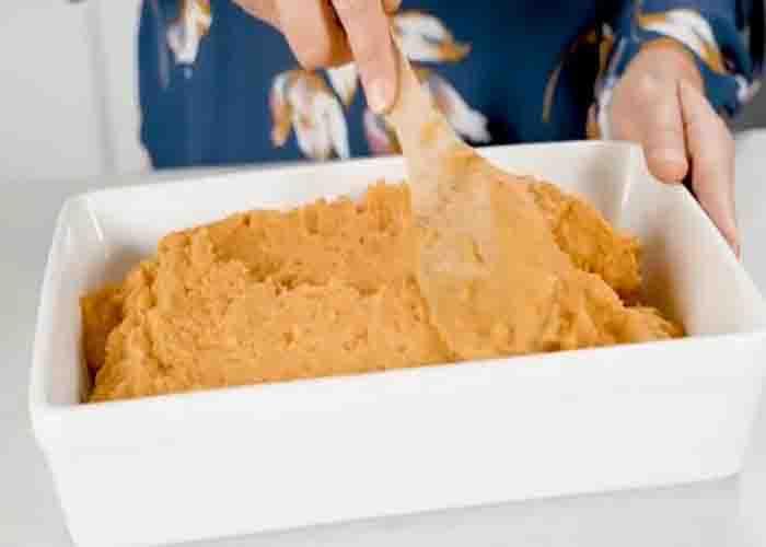 Transferring the sweet potato to the casserole dish