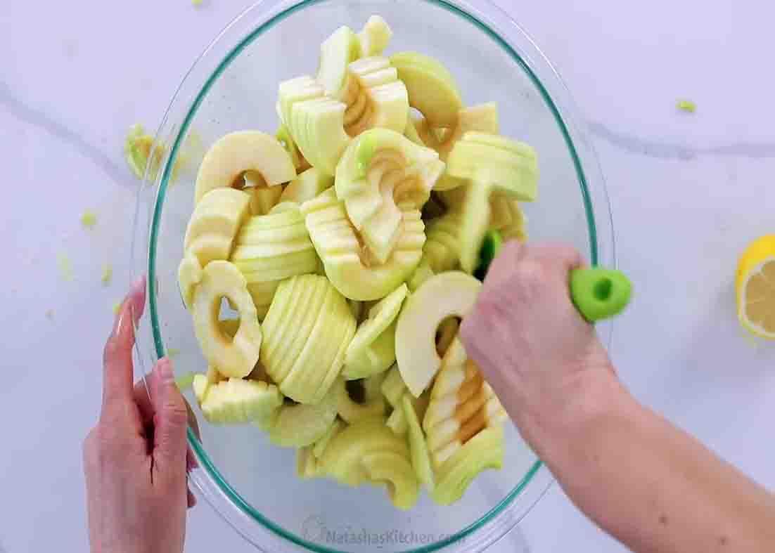 Adding lemon juice to the sliced apples